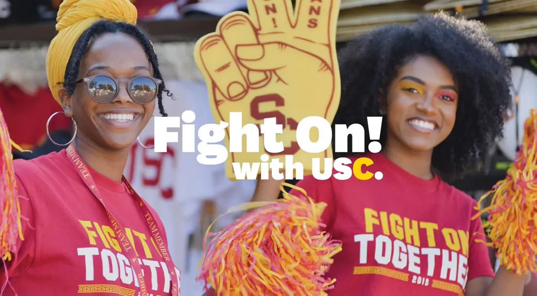 the words Fight On! with USC over two women smiling at an athletics event